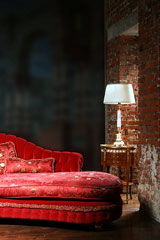 table lamp with white lamp shade adjoining a red sofa
