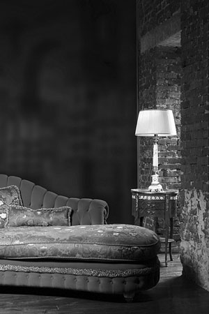 table lamp with white lamp shade adjoining a red sofa